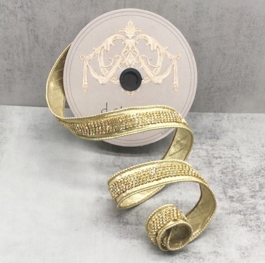 a gold-colored ribbon with a decorative pattern, placed on a gray surface.