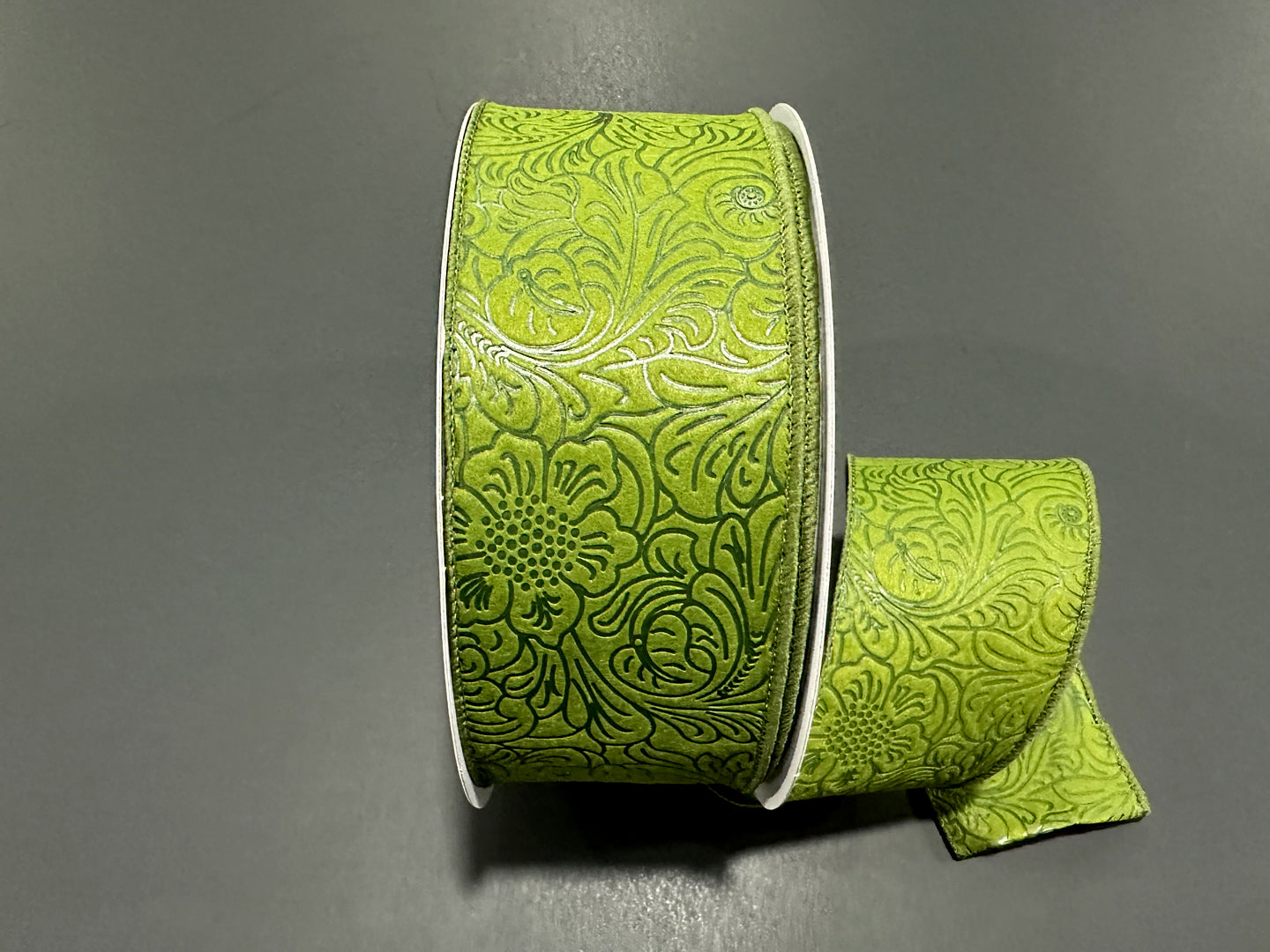 a roll of green decorative ribbon on a table