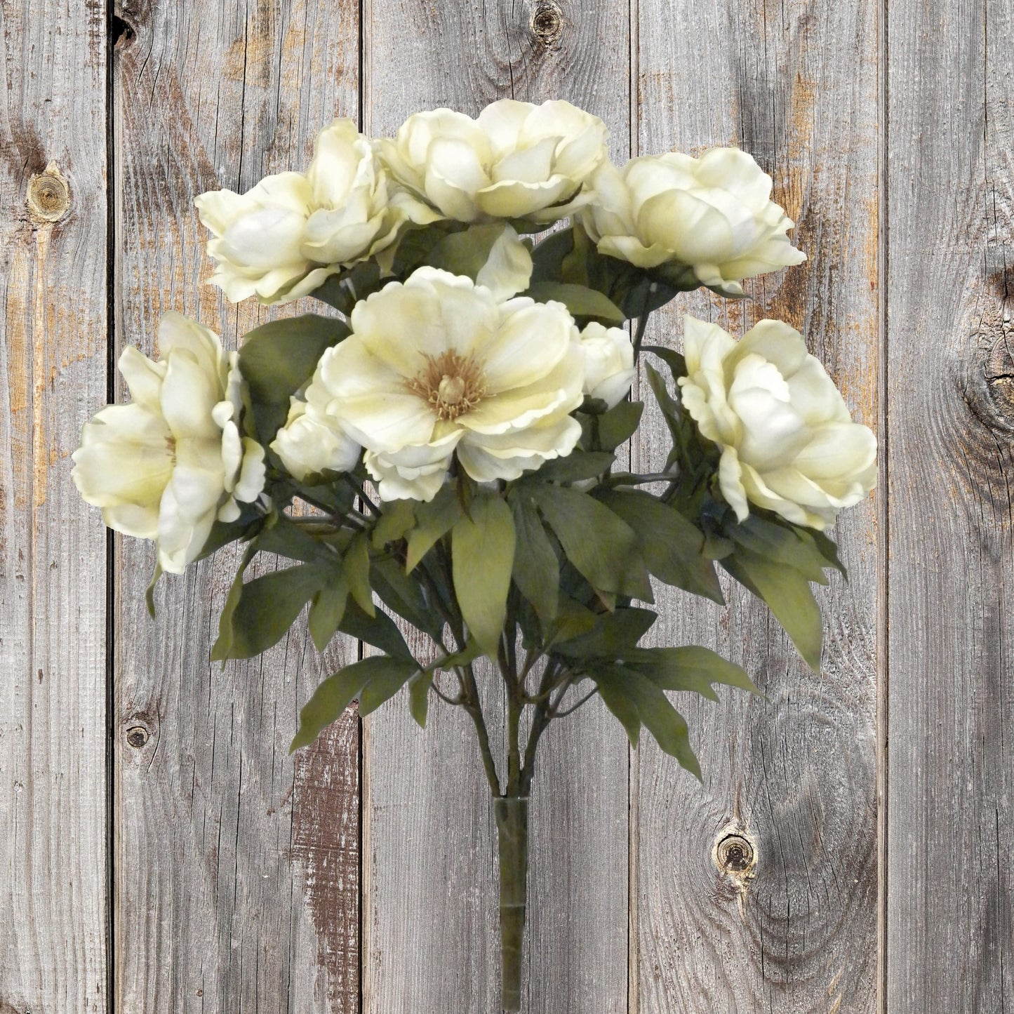 A bouquet of white flowers in a vase, set against a rustic wooden background.
