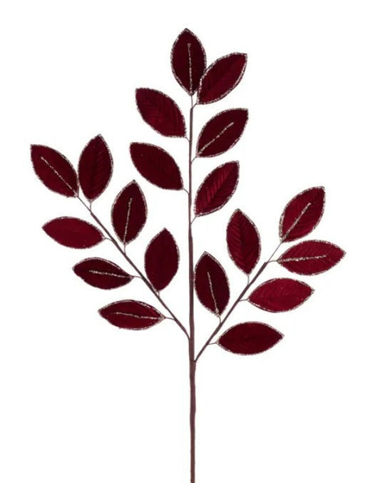A branch with red leaves, possibly artificial, against a white background.