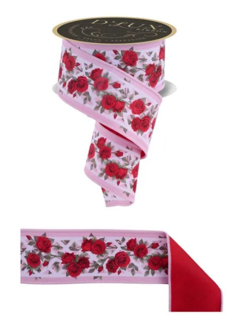 a pink ribbon with a floral pattern of red roses on it.