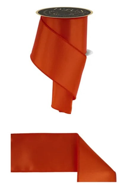 a red ribbon with a black circular object on top of it.