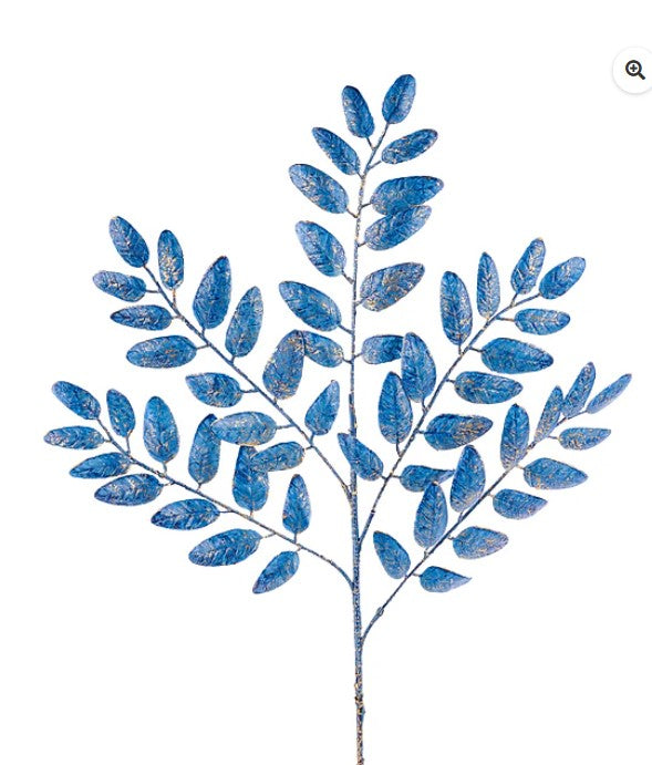 A branch with blue leaves, possibly artificial, against a white background.