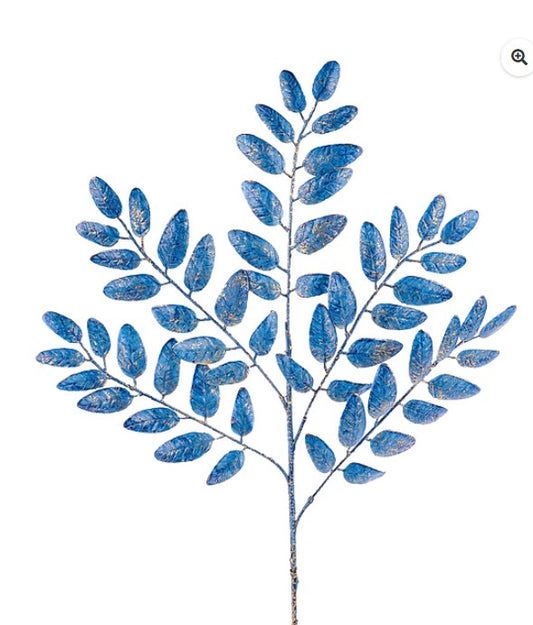 A branch with blue leaves, possibly artificial, against a white background.