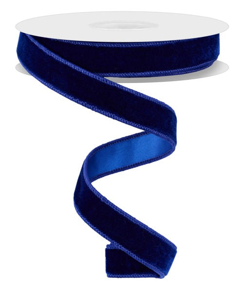 a roll of blue velvet ribbon on a white background