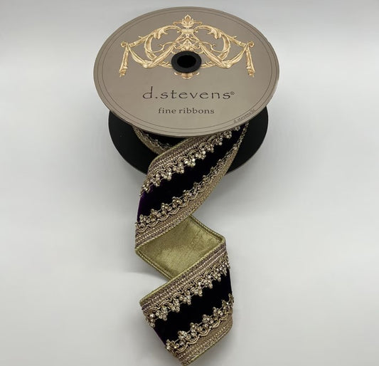 A roll of decorative ribbon with a gold and black pattern, placed on a white background.