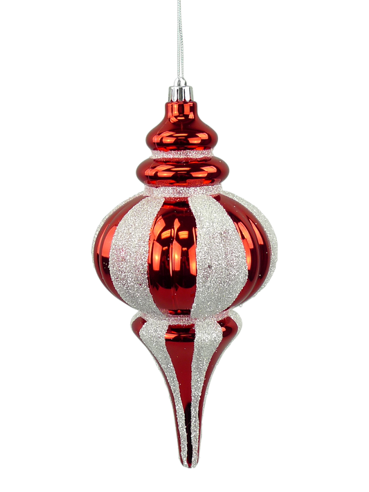 A red and white striped ornament with a pointed top and a long, thin body is suspended from a string.