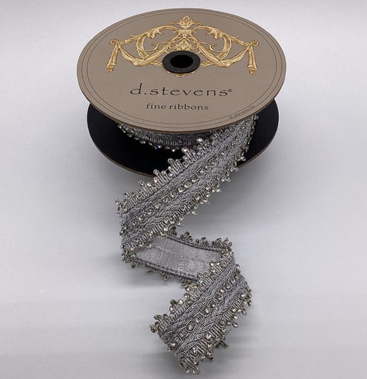 A spool of silver ribbon with a decorative trim, placed on a plain background.