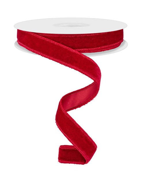 a roll of red velvet ribbon on a white background