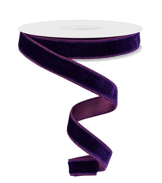 a roll of purple velvet ribbon on a white background