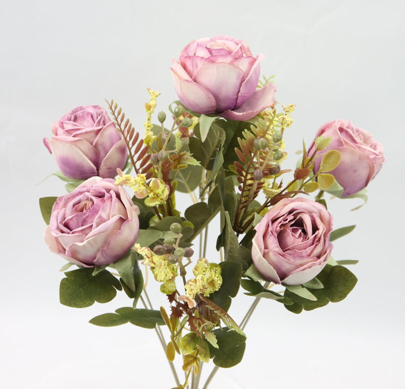 a vase filled with pink roses and greenery