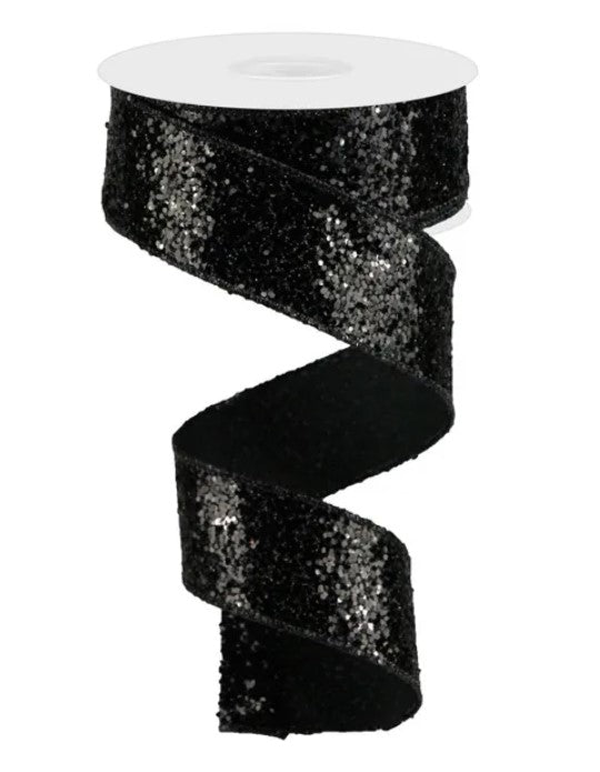 A black sequin ribbon with a spiral pattern, sitting on a white surface.