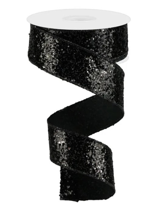 A black sequin ribbon with a spiral pattern, sitting on a white surface.