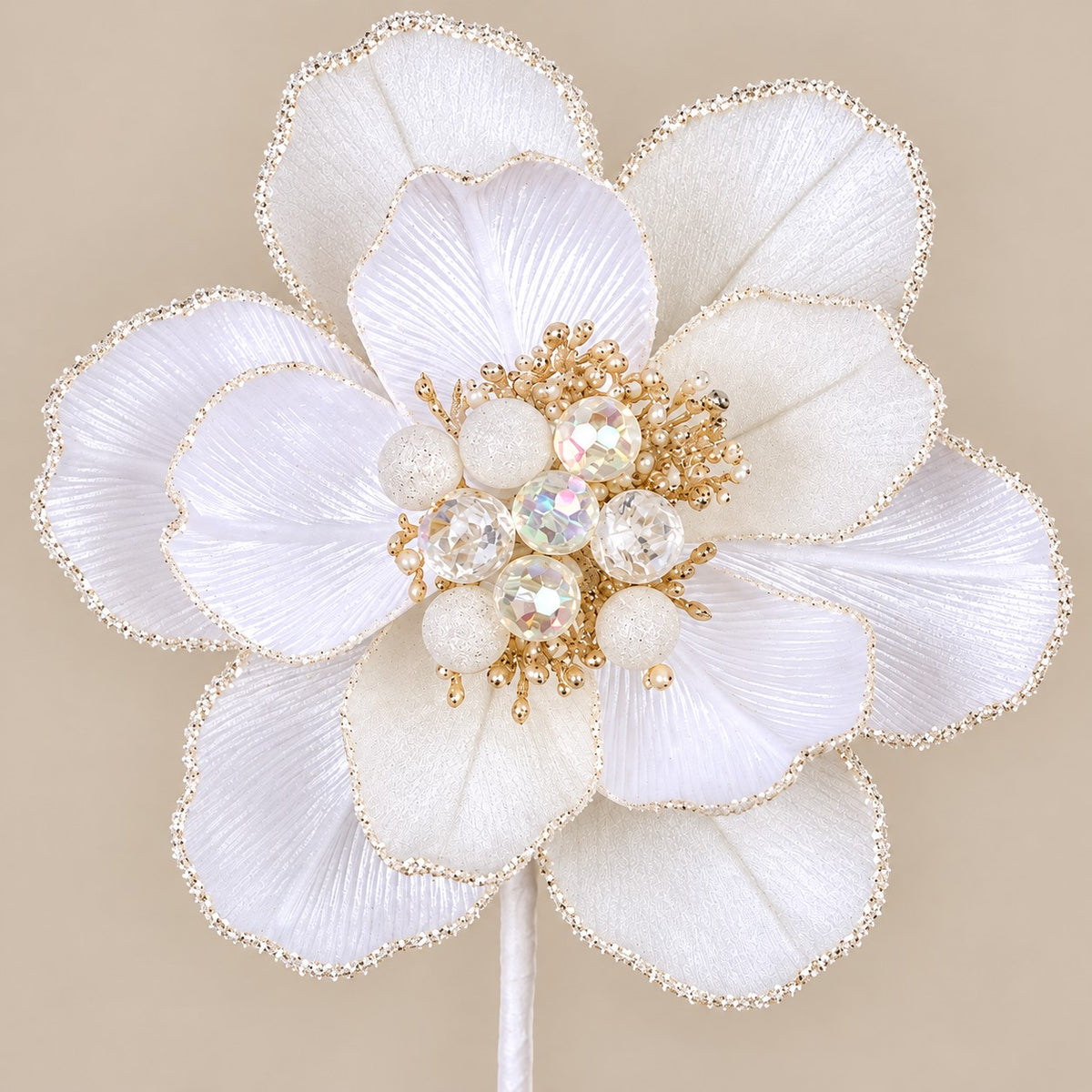 A close-up of a white flower adorned with gold and crystal embellishments.