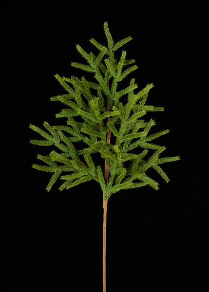 A small, green artificial tree with numerous branches stands against a black background.