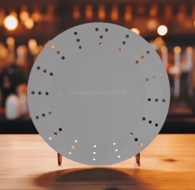 a grey circular object with small holes, placed on a wooden surface.