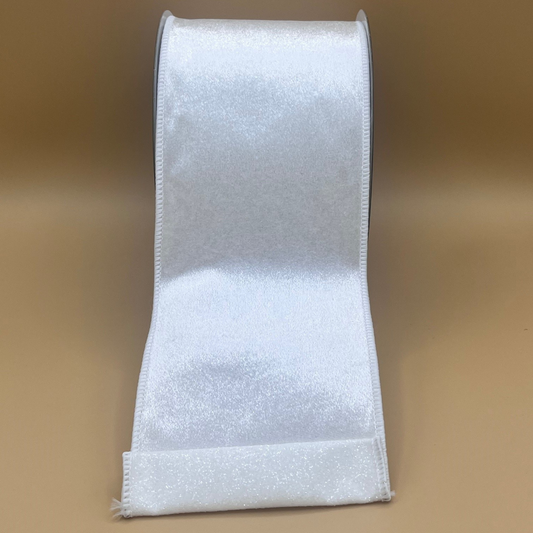 A roll of white satin ribbon against a beige background.