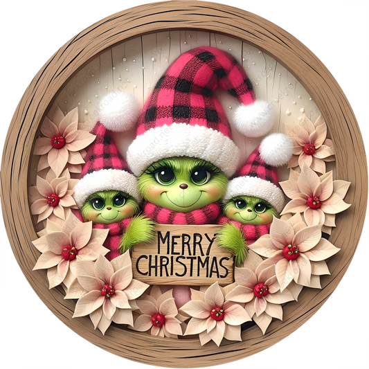 a christmas ornament with two green babies in a santa hat