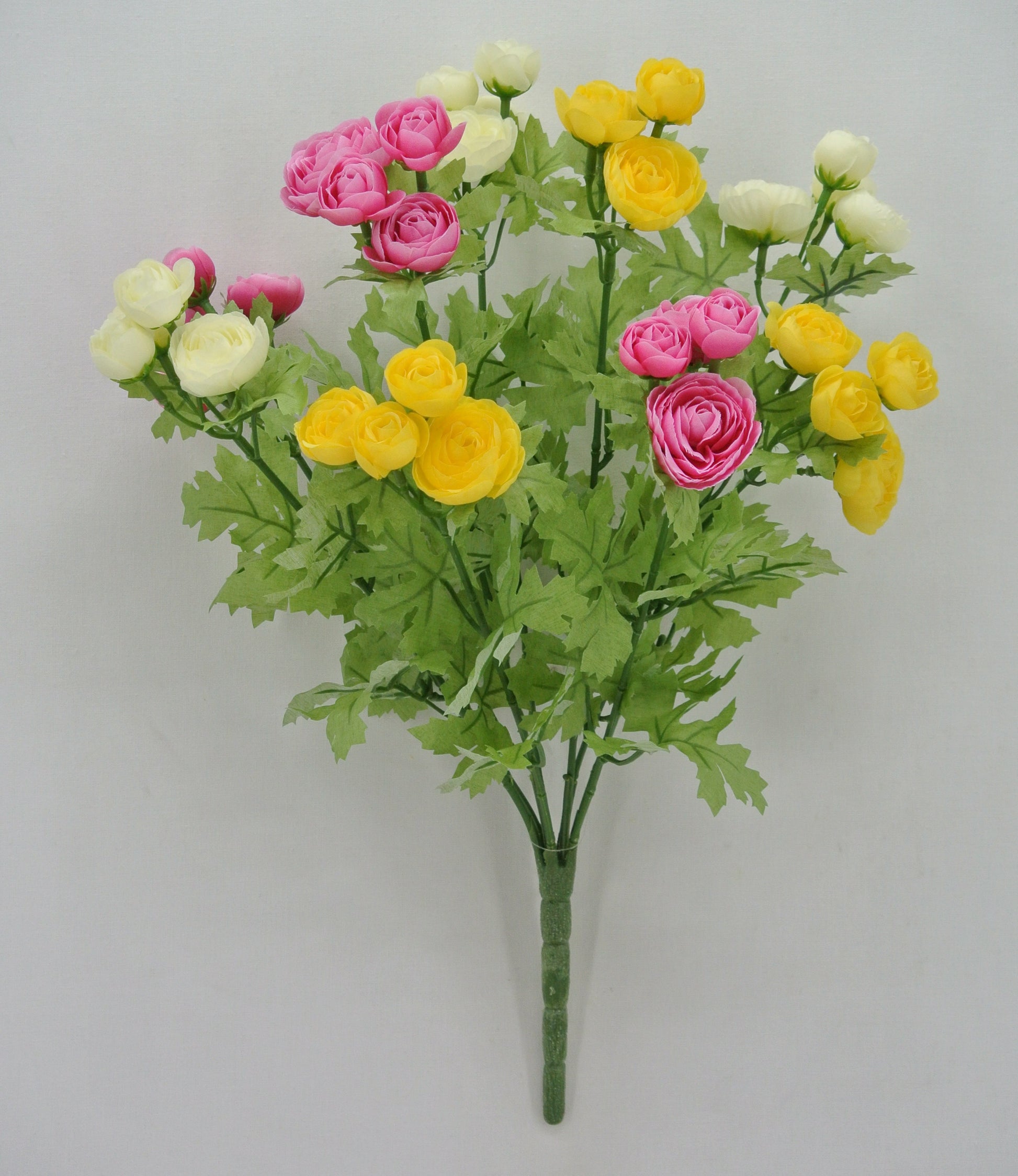 A bouquet of colorful artificial flowers, including pink, yellow, and white roses, arranged in a lush green stem.