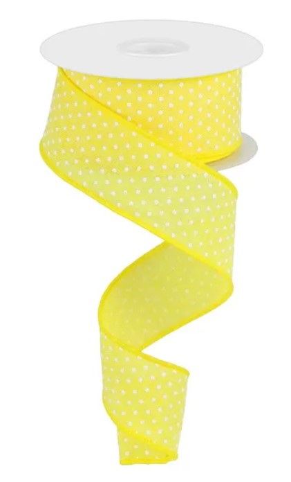 A roll of yellow polka dot ribbon with a white backing.
