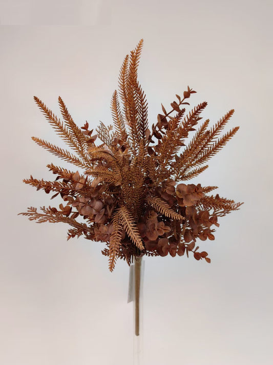 A bouquet of dried ferns and other brown foliage arranged in a vase.