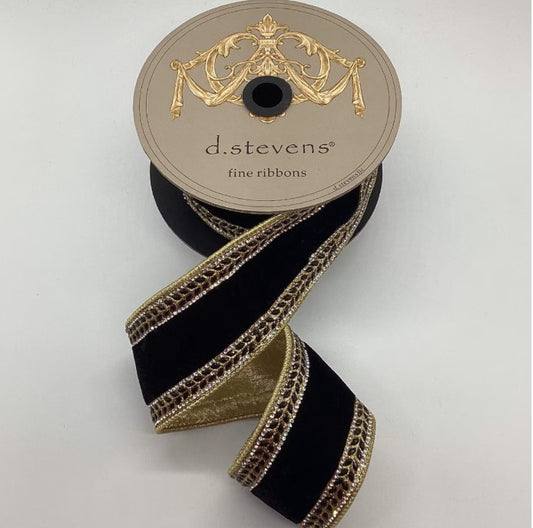 A spool of black velvet ribbon with gold trim, featuring an ornate design, is displayed against a white background.