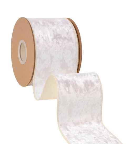 A roll of white velvet ribbon with a brown cardboard spool attached, against a white background.