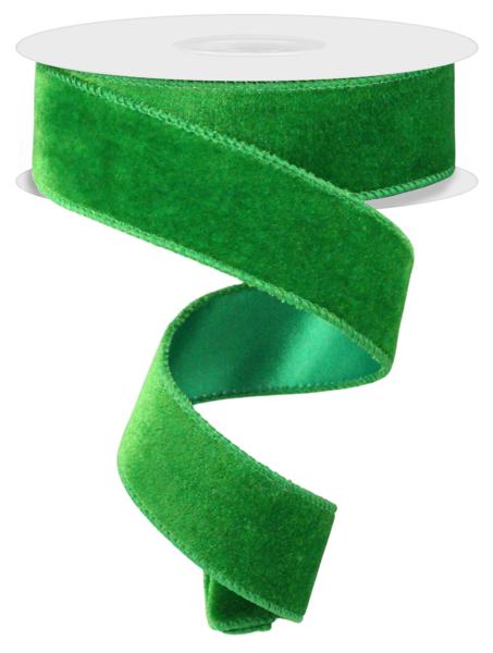 a roll of green velvet ribbon on a white background