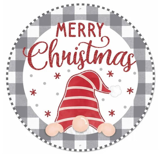 A round sign with a red and white plaid border, featuring a red and white striped gnome hat and snowflakes. The text "MERRY CHRISTMAS" is written in a decorative script above the gnome hat.