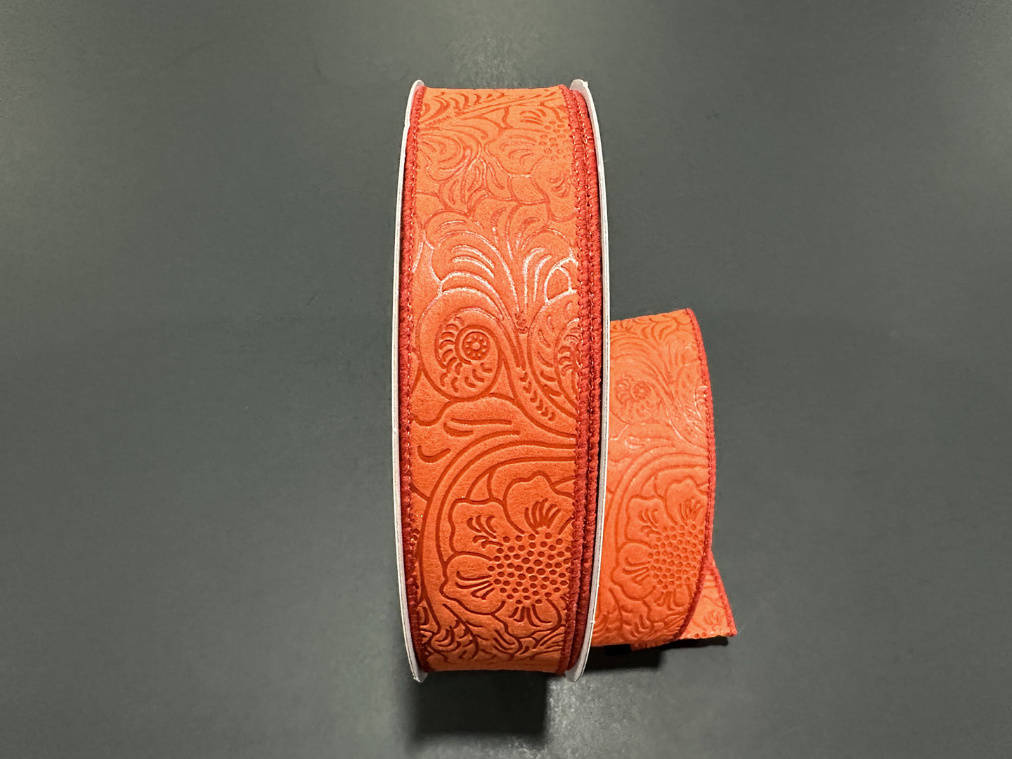 a pair of orange leather bracelets on a table