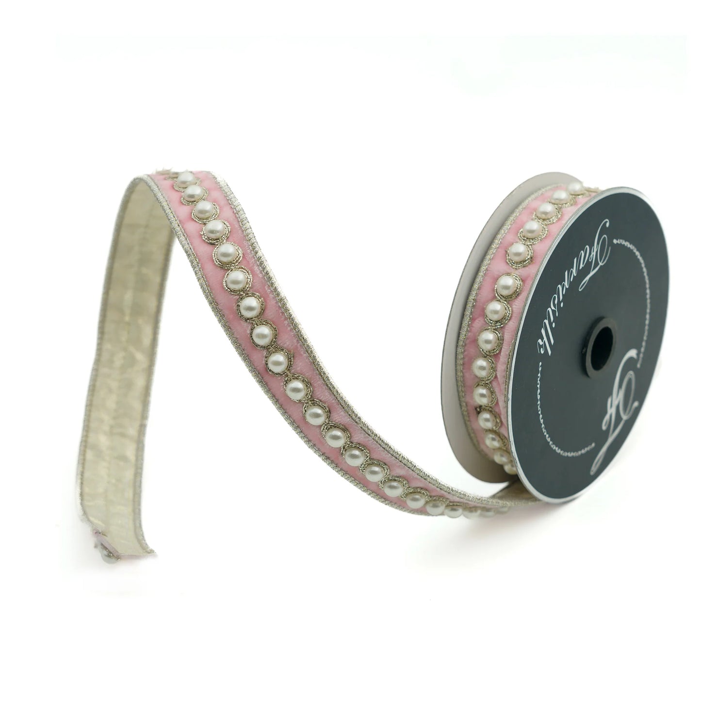 A roll of decorative ribbon with a pink and white pattern of small pearls and a black background.