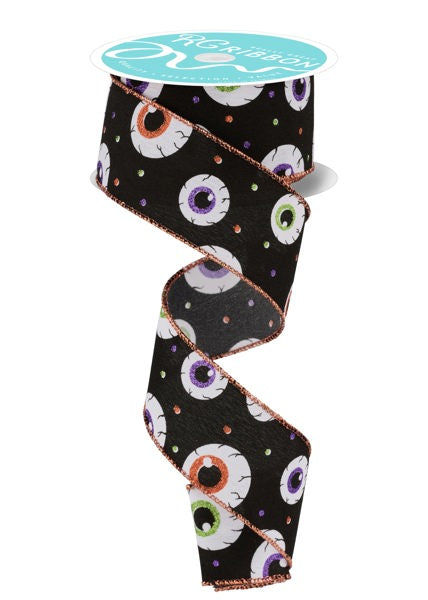 A spool of black ribbon with a pattern of white and purple eyeballs printed on it.