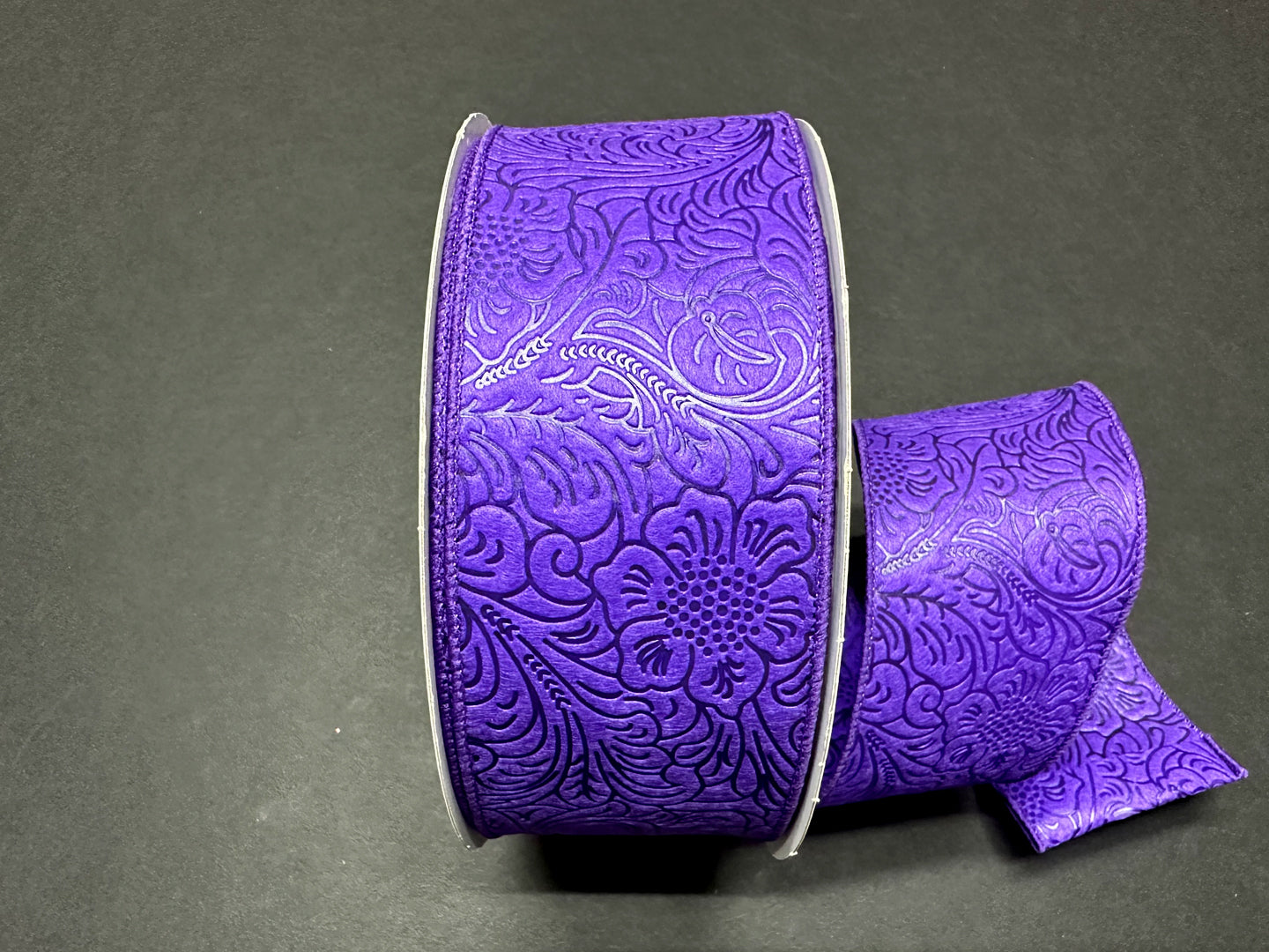 a purple ribbon with a flower design on it