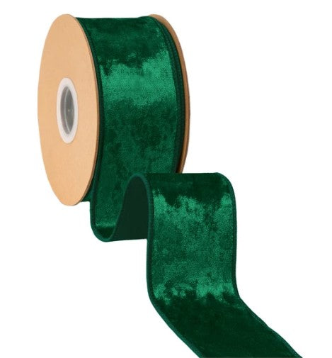A roll of green velvet ribbon with a wooden spool.
