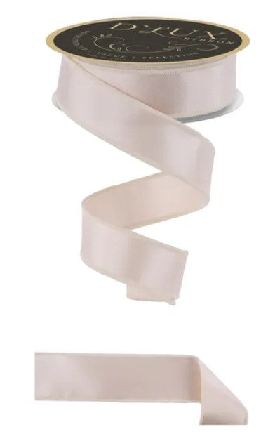 a roll of pale pink ribbon with a black label, and a piece of the ribbon is visible on the bottom right side of the image.