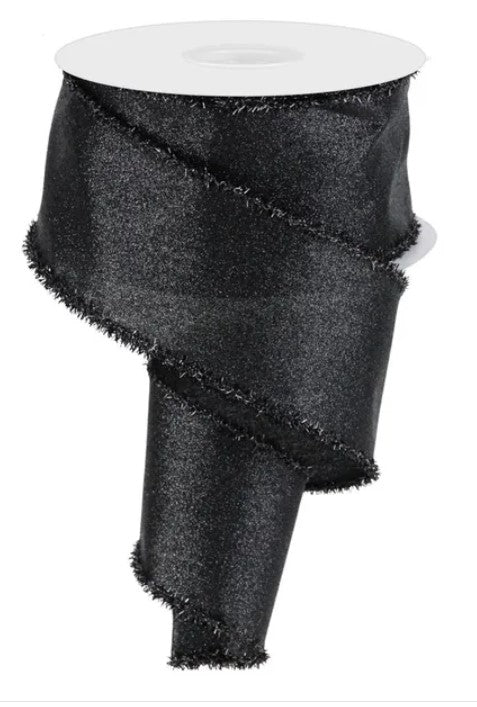 a black, shiny, and textured ribbon or fabric with a fringed edge, sitting on a white surface.
