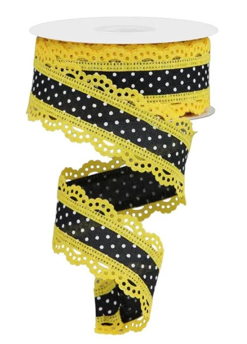 A spool of ribbon with a black and yellow pattern, featuring a lace-like design along the edges.