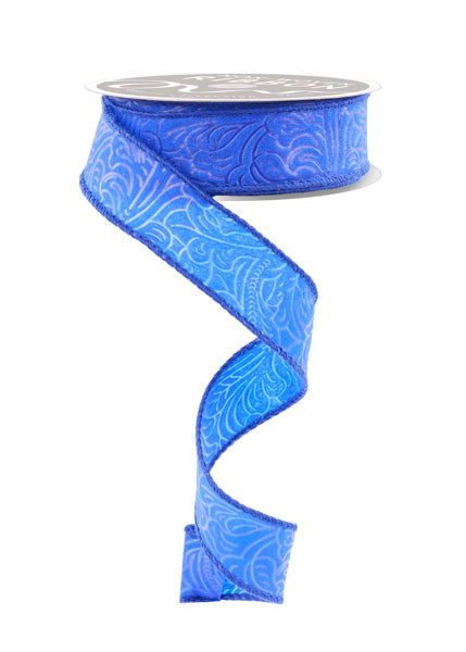 A blue floral patterned ribbon is shown, winding around a spool of ribbon.