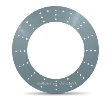 a grey circular object with small holes arranged in a pattern around the edge.