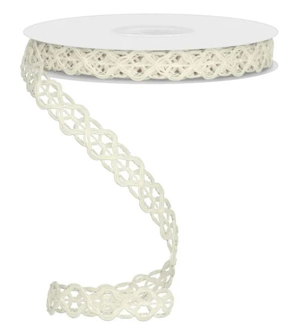 A spool of white lace-like ribbon with a decorative pattern on it.