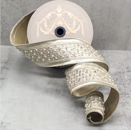 a decorative silver ribbon with a beige and gold floral pattern, placed on a gray surface.