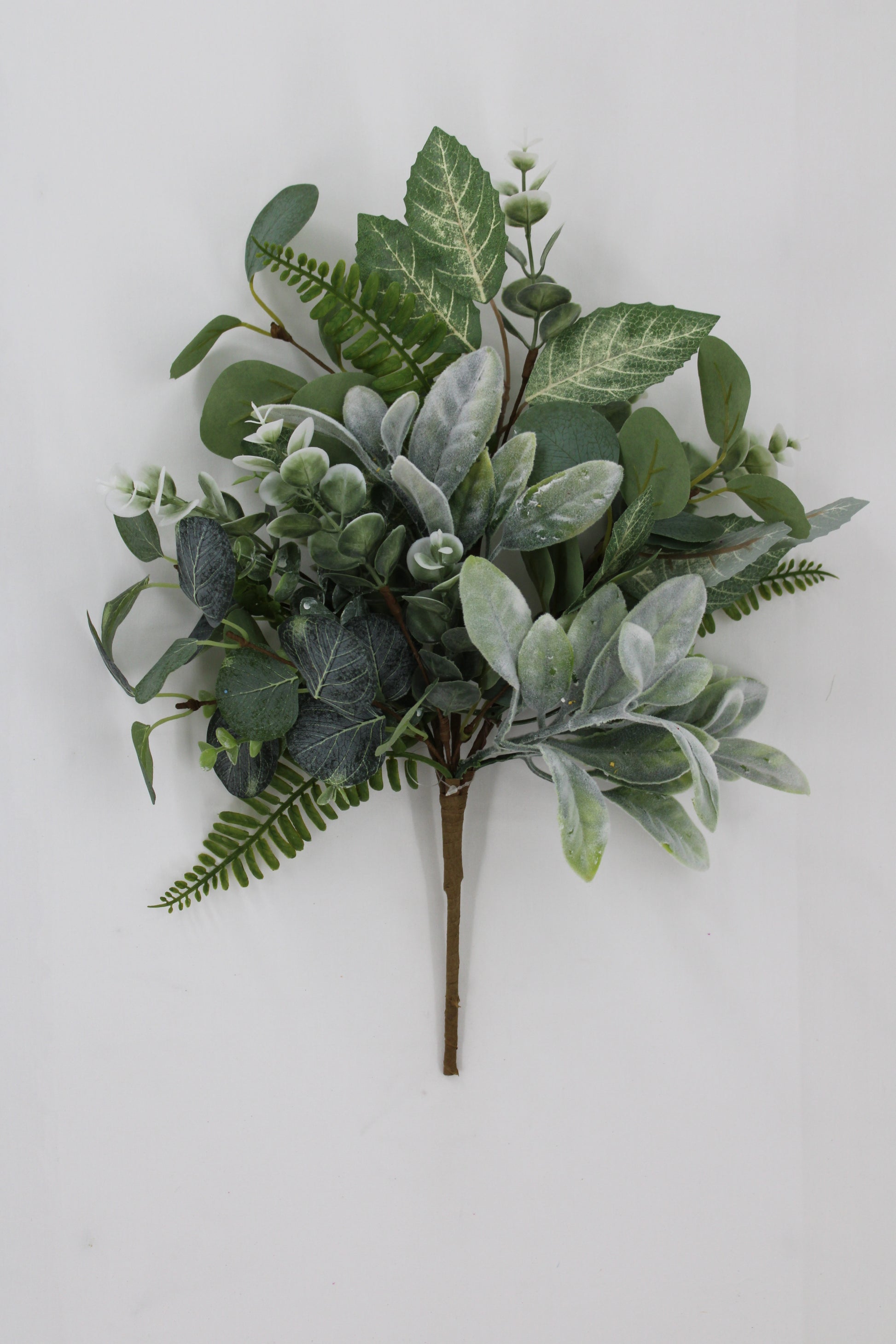 A bouquet of various green leaves and ferns arranged on a white background.