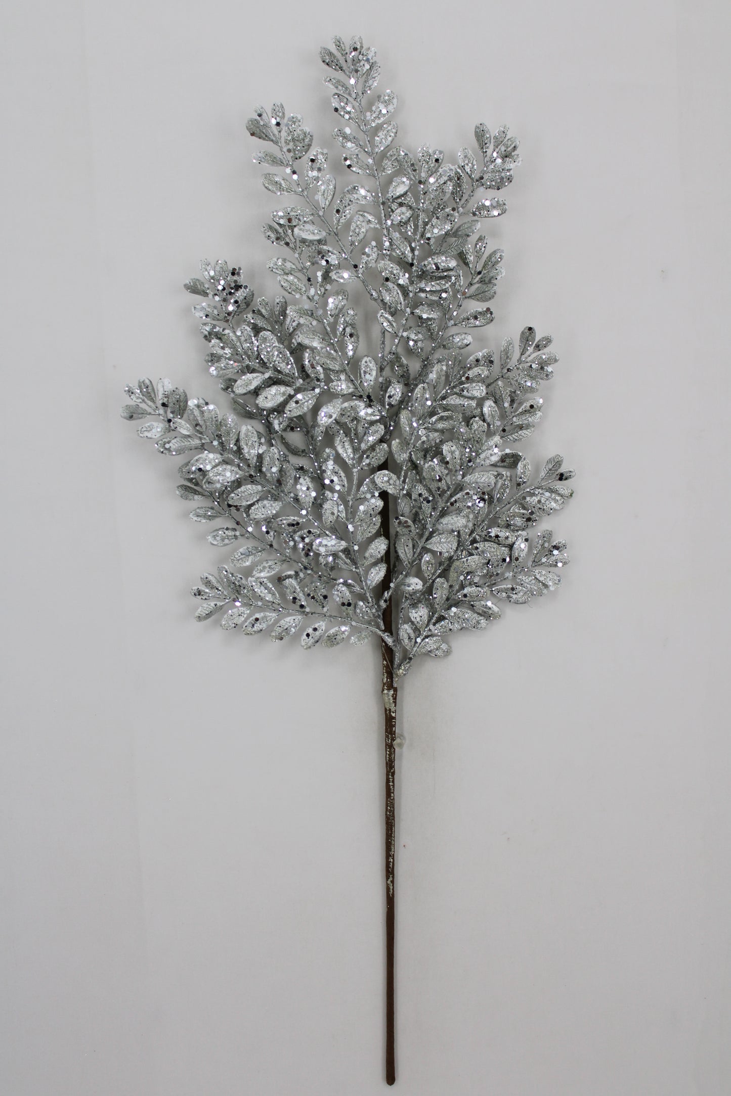 A silver leafy branch with small, shiny leaves attached to it, creating a decorative and elegant appearance.