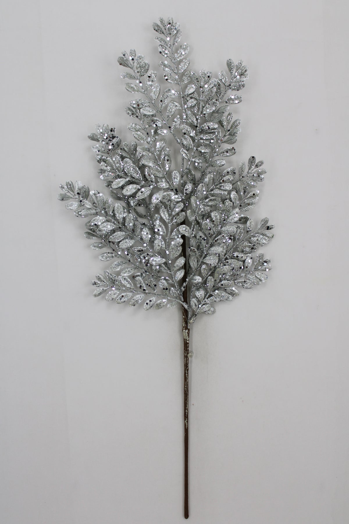 A silver leafy branch with small, shiny leaves attached to it, creating a decorative and elegant appearance.