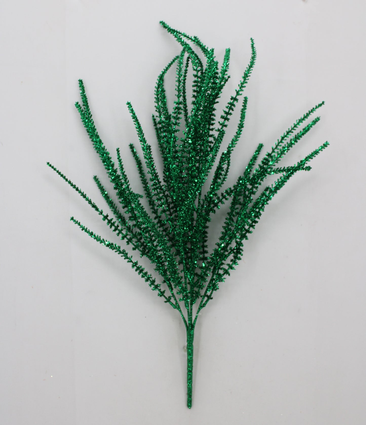 A green, glittery, spiky plant or branch with multiple thin, pointed leaves or stems.