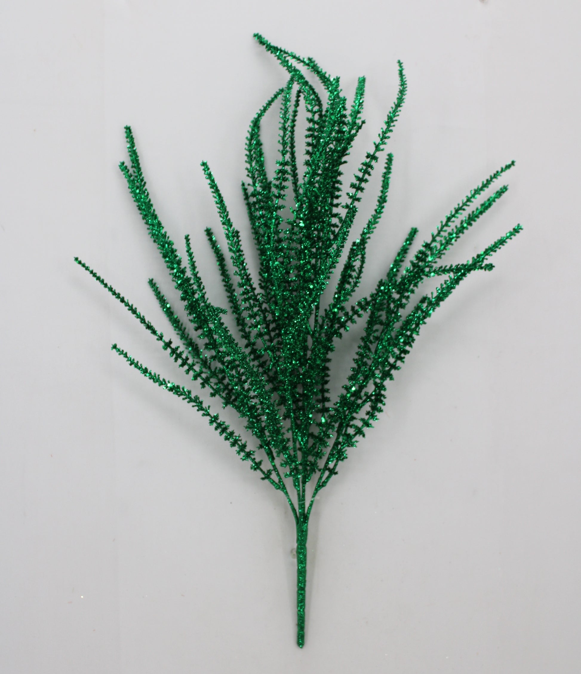 A green, glittery, spiky plant or branch with multiple thin, pointed leaves or stems.