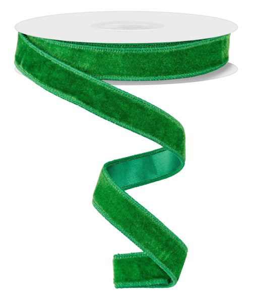 a roll of green velvet ribbon on a white background