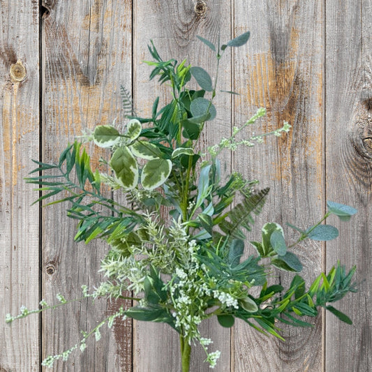 A lush arrangement of green leaves and flowers is displayed against a weathered wooden background.