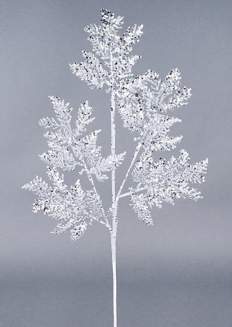 A single, white, snowflake-like branch with intricate, sparkling patterns against a gray background.