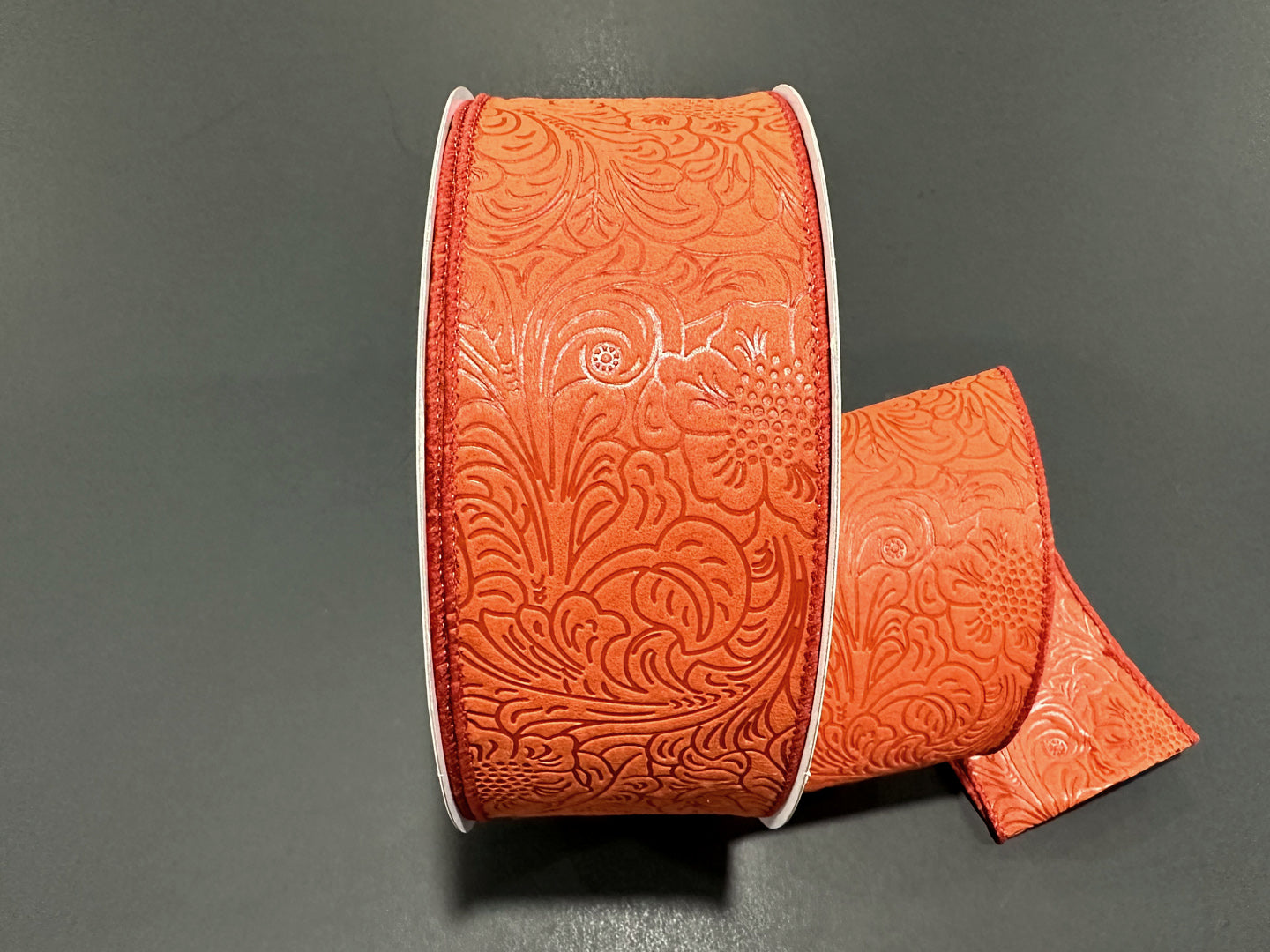 a roll of orange leather with a design on it